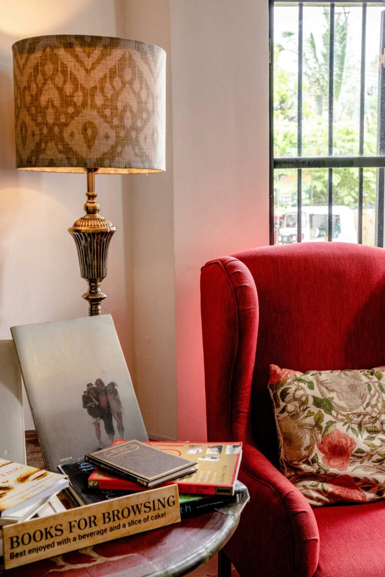 Inviting reading nook featuring a red armchair and decorative lamp.